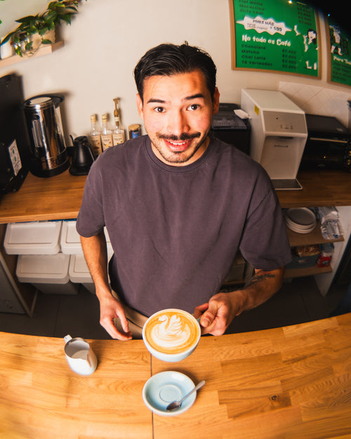 Barista mostrando un latte recién preparado